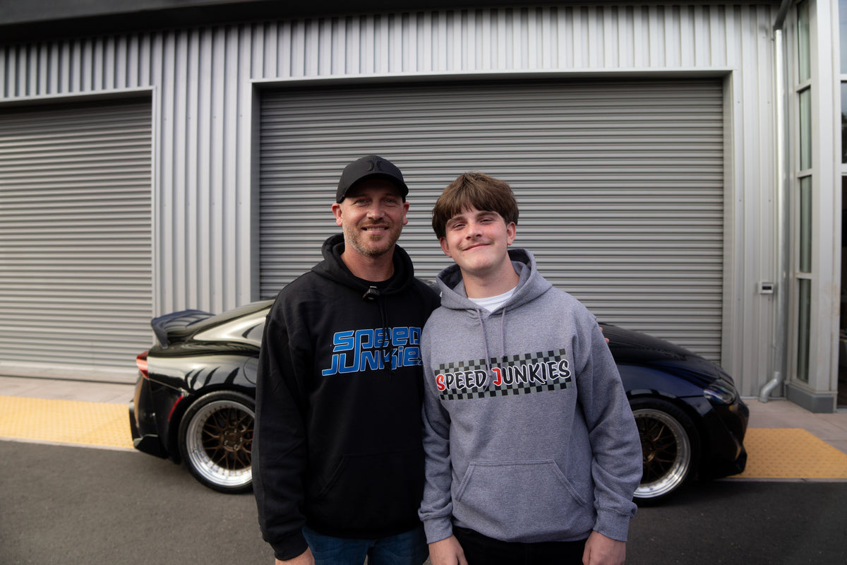 Axel B. of South Carolina and his son in Speed Junkies hoodies, in front of the black Toyota A90 Supra he won